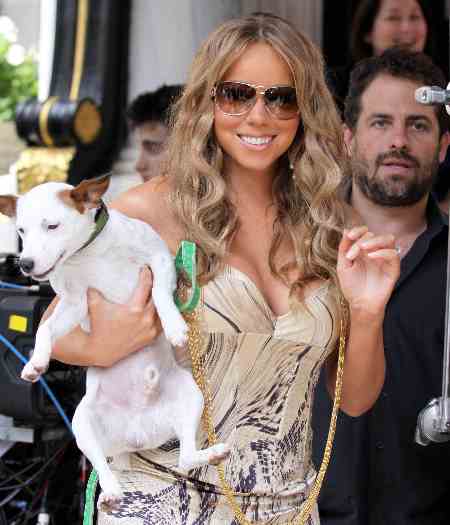 A cantora norte-americana Mariah Carrey carrega seu cachorrinho Jack