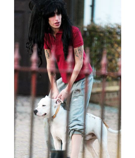 A cantora britânica Amy Winehouse com seu cão em frente de casa