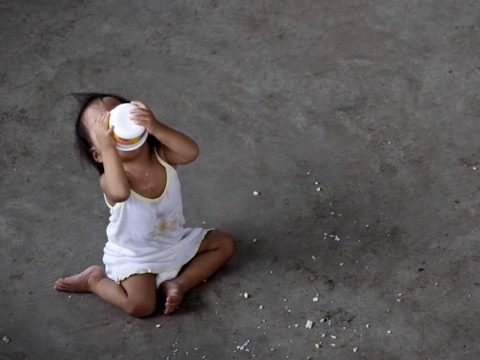 Menina toma café da manhã em centro para desabrigados nas Filipinas, depois que o tufão Parma passou pela região e deixou ao menos 17 mortos; apesar disso,...