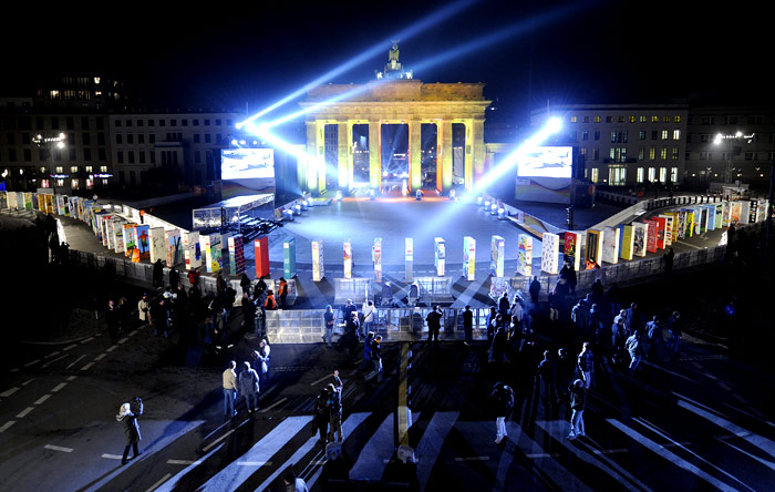 Portão de Brandenburgo é iluminado na noite de domingo (8) em Berlim. Cerca de mil peças gigantes de dominó foram colocadas no local representando o Muro. ...