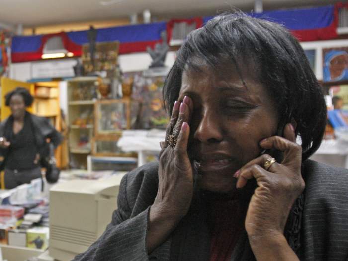 Edeline B. Clermont  chora no "Pequeno Haiti", área de Miami, enquanto fala com sua irmã em Boston. Elas não conseguiam contatar seus familiares no Haiti