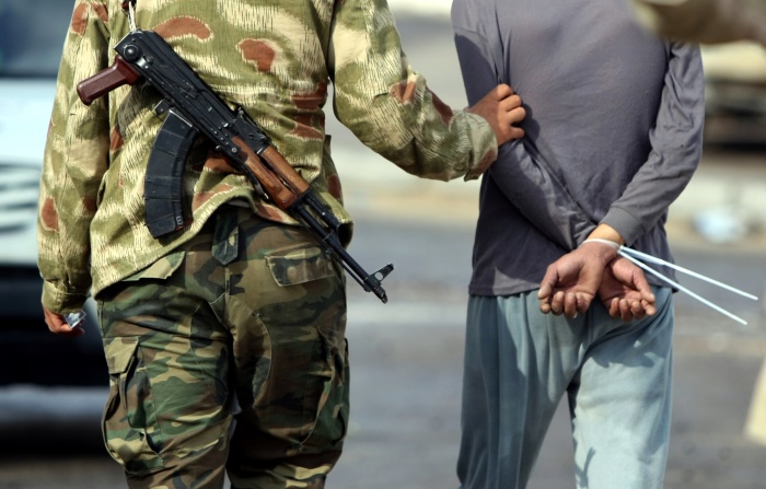 Soldado rebelde escolta prisioneiro supostamente ligado à resistência leal ao ditador Muammar Gaddafi em Sirte, no oeste do país. Segundo a ONU, cerca de 7.000 pessoas já foram presas pelos rebeldes desde o início do conflito (Ahmad Al Rubaye/13.10.2011/AFP) preso-libia