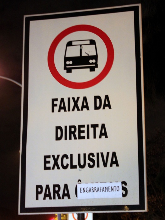 Os registros de congestionamento na avenida W3 Sul e no Setor Policial Sul aumentaram após a implementação das faixas exclusivas para ônibus e têm sido frequentes. O trânsito fica lento durante os horários de pico e usuários de transporte coletivo e motoristas reclamam da situação. Para mostrar sua indignação, um morador de Brasília fez um protesto ao pregar a palavra "engarrafamento" nas placas de trânsito que indicam a exclusividade da via na W3 Sul. A foto foi feita pela internauta Mirian Medeiros e enviada ao portal R7 DF. Na tarde desta segunda-feira (18), Detran-DF e DFTrans estão reunidos para decidir sobre a manutenção da faixa nas duas vias.
(Mirian Medeiros)
Moradores de Brasília protestam contra faixa exclusiva na W3 Sul