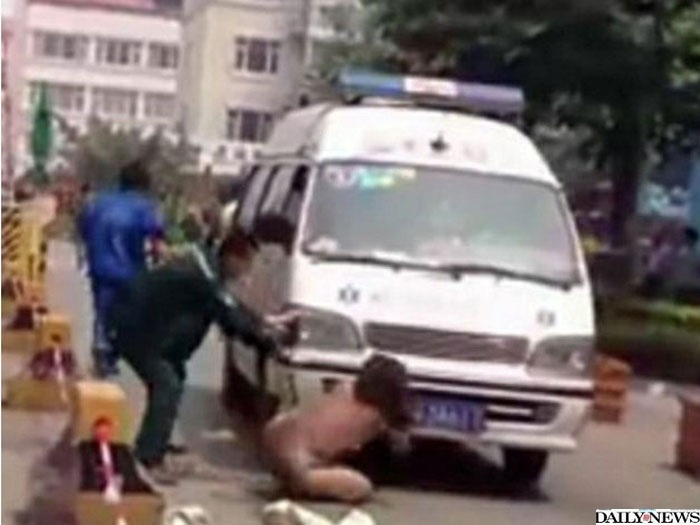 A chinesa tirou a roupa e deitou na frente da ambulância que levava a amante do marido e a filha dela para o hospital (Reprodução/nydailynews.com) .