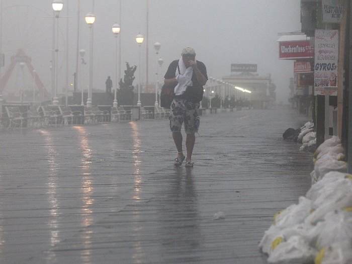 Pedestre tenta se proteger dos ventos fortes e da chuva, que chega com o furacão Irene à Outer Banks, no litoral da Carolina do Norte
