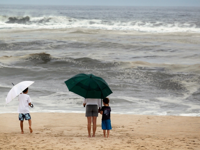 Moradores observam as ondas em Water Mill, Nova York, onde mar ficou agitado por conta do furacão Irene, que deve chegar à região na madrugada deste doming...