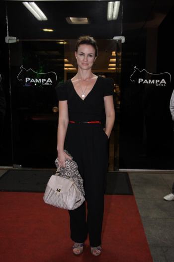 AgNews A atriz Carolina Kasting usou um macacão preto com decote v. Ela completou o look com sandálias de tiras mais grossas e um cinto fininho vermelho marcando ...